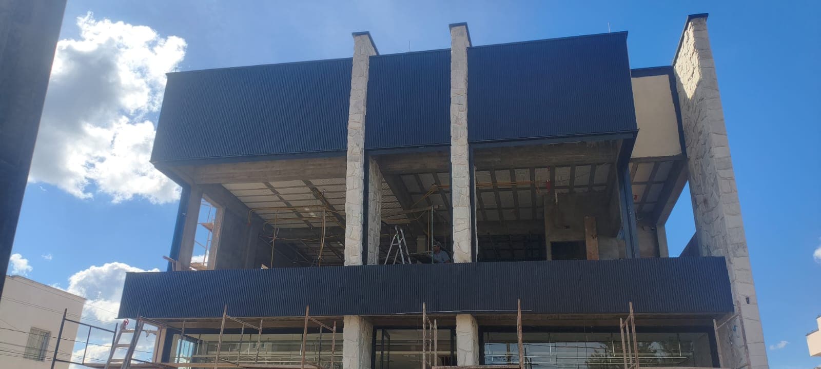 Fachada de loja Original — ângulo noturno com ripados
